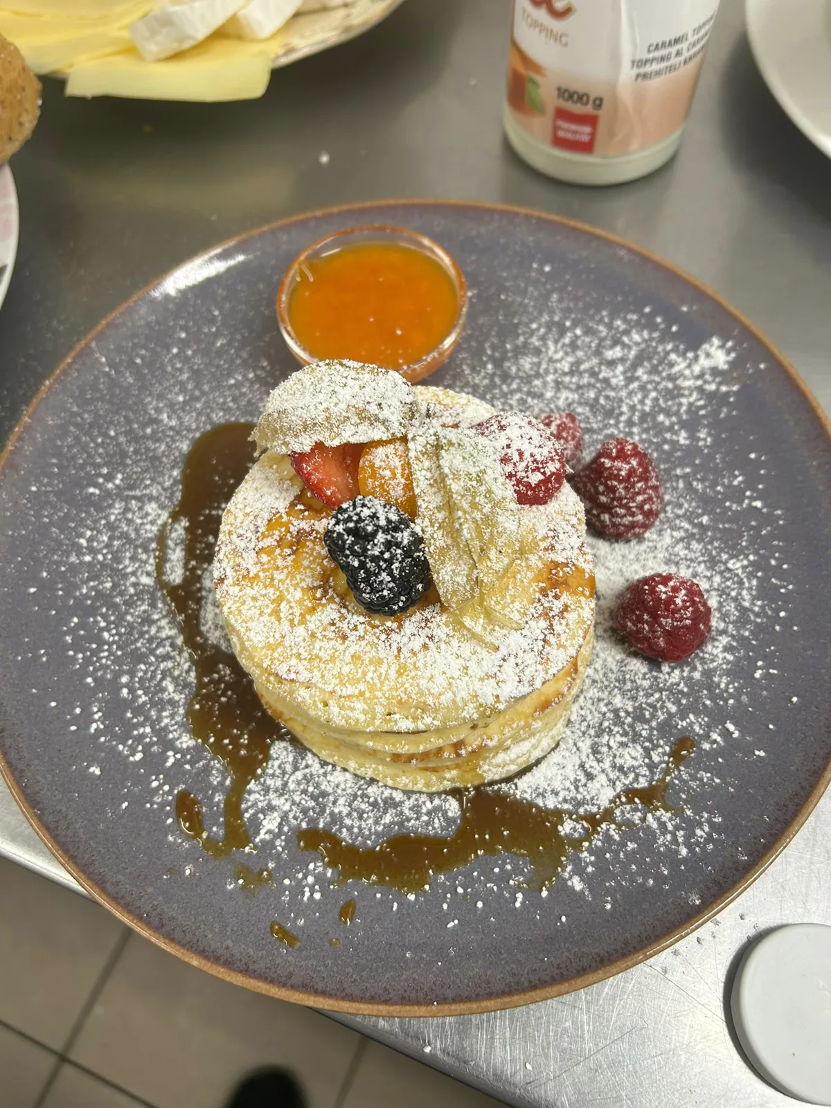 Pancakes mit Beeren, Staubzucker und Fruchtsauce